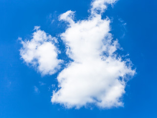 two fluffy clouds in dark blue sky in summer day