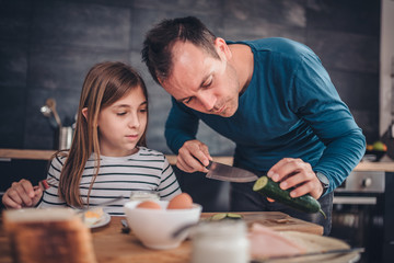 Father preparing breakfast for daughter