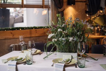 served table near the window with a bouquet of wild flowers