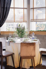 served table near the window with a bouquet of wild flowers