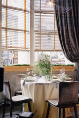 served table near the window with a bouquet of wild flowers