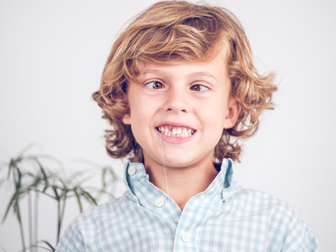 Little boy pulling tooth out making faces