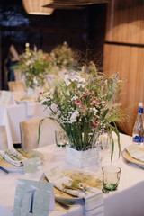 white vase with wildflowers on a festive table