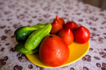 Juicy and tasty tomatoes with cucumbers on a plate