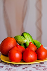Juicy and tasty tomatoes with cucumbers on a plate