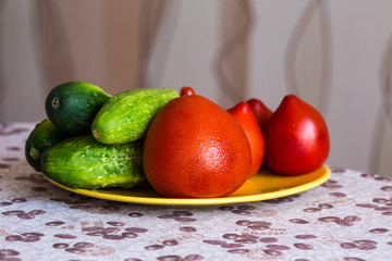 Juicy and tasty tomatoes with cucumbers on a plate