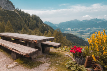 eine verwitterte Bank und Tisch zur Rast mit Ausblick auf Berg und Tal