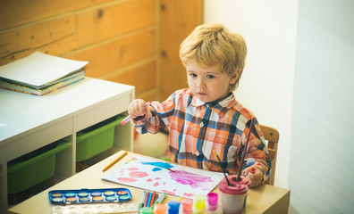 Art. Art therapy for children. Boy draws bright picture on the children's table. Cute young artist enjoys creativity. Happy childhood and emotional art class. Creative development for children