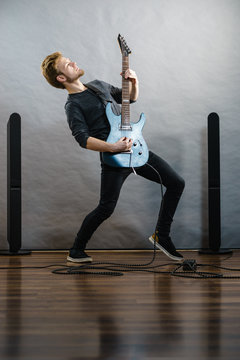 Young man playing electric guitar