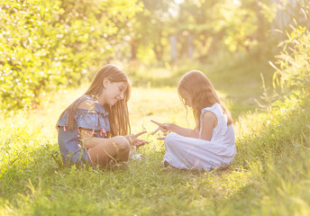 Two girls playing rock paper scissors game outdoors