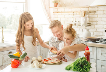 dad with daughters preparing pizza