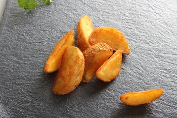 country slices potatoes on a dark stone background
