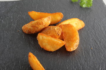 country slices potatoes on a dark stone background