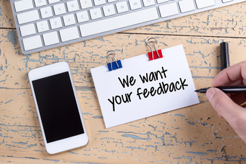 Paper note with text We want your feedback