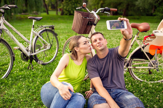 young couple in love taking selfies with smartphone in the park.