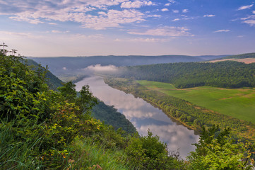 Beautiful summer landscape with morning fog over the river. Dniester Canyon, Ukraine, Europe