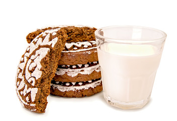 pile of gingerbreads with two halves and a glass of milk isolated on white with clipping path