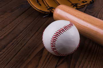 Baseball bat, ball and glove wooden table. Closeup