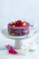 frozen blueberry lemon cake from ice cream and fresh berries on a cake stand on a marble table. summer festive dessert