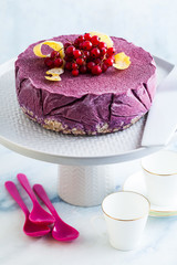 frozen blueberry lemon cake from ice cream and fresh berries on a cake stand on a marble table. summer festive dessert