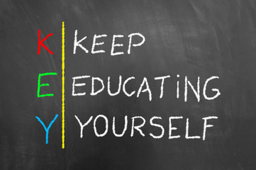 Key keep education yourself text on blackboard.