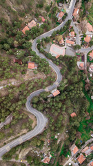 aerial view of curvy hill road surrounded with trees and houses, Cyprus