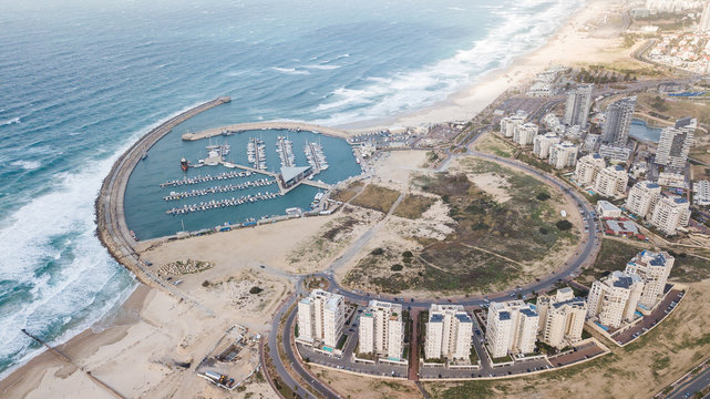 aerial view of circle arranged houses and harbor on sea coast, Ashdod, Israel