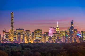 New York City skyline over Central Park at dusk.