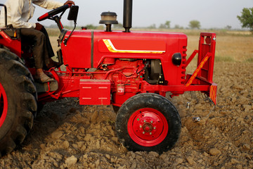 Farmer working in the field using tractor.