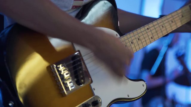 Guitarist strumming a tobacco colored telecaster