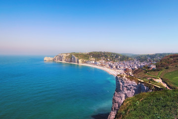 Naklejka premium Picturesque landscape of Etretat in sunny spring day. View from the mountain to the city and the streets of Etretat and the English Channel. Etretat, Seine-Maritime department, Normandy, France