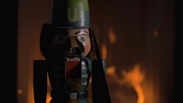 Wooden Nutcracker Near a Burning Fireplace