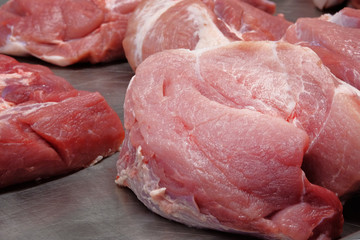 Fresh raw meat is sold on counter of local farmers market.