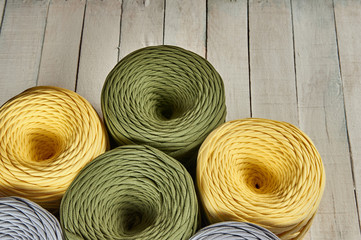 coils of colored knitted yarn on a white wooden background
