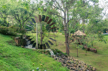 Working old wooden watermill wheel with falling water in the village