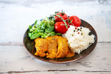 Rice and chicken on dark plate