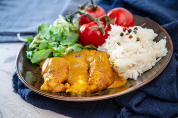 Rice and chicken on dark plate