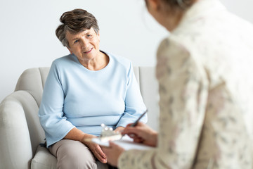 Excited grandmother talking with psychologist about positive life of pensioner