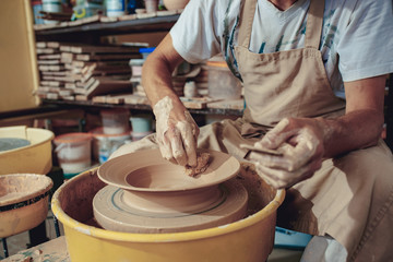 Creating a jar or vase of white clay close-up. Master crock. Man hands making clay jug macro.