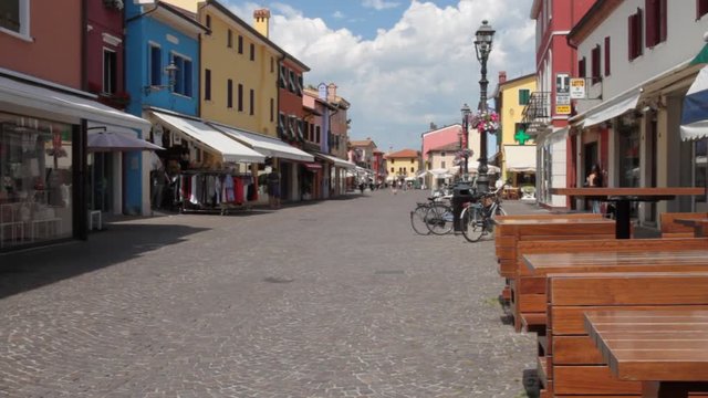 Street in the historic center of Caorle with tourists on walks