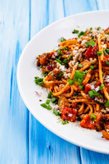 Pasta with meat and tomato sauce on wooden table