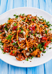 Pasta with meat and tomato sauce on wooden table