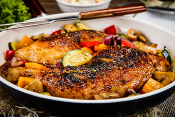 Roast chicken legs served on frying pan