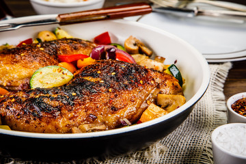 Roast chicken legs served on frying pan