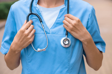 cropped image of medical student holding stethoscope on neck