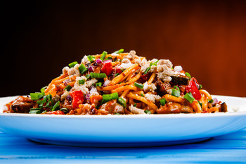 Pasta with meat and tomato sauce on wooden table