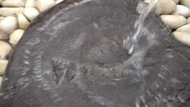 water running on a stone surface in slow motion