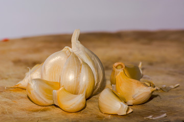 sliced garlic, garlic clove, garlic bulb in wicker basket place on chopping block on vintage wooden background
