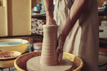 Creating a jar or vase of white clay close-up. Master crock. Man hands making clay jug macro.