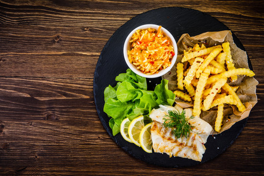 Fish dish - fried fish fillet with french fries and vegetables